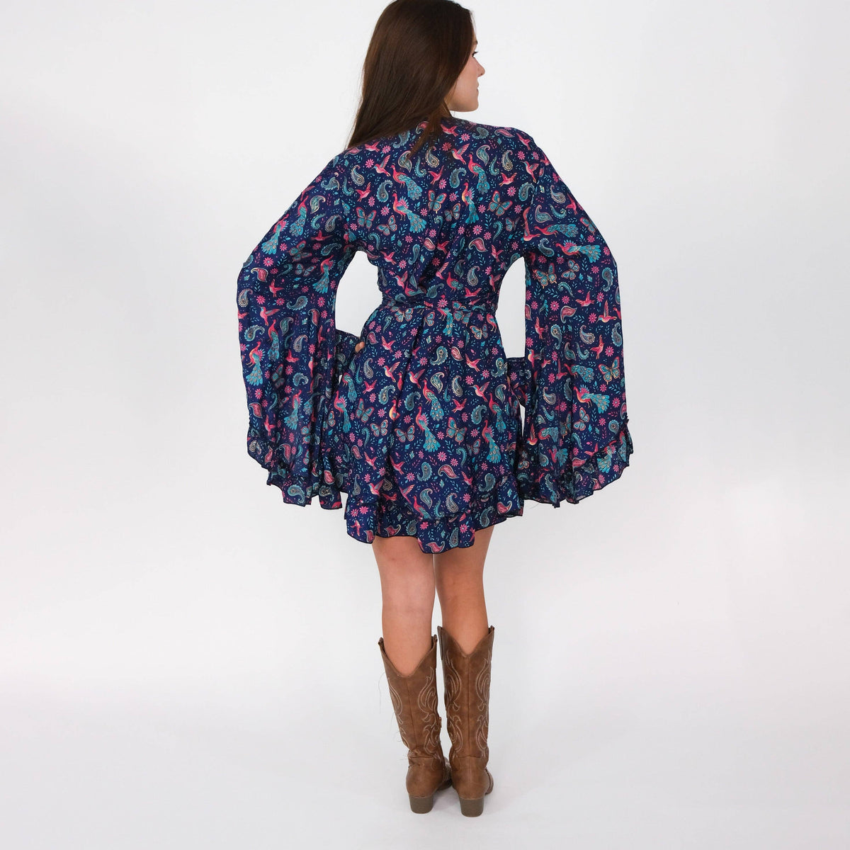 Woman wearing a patterned dress with long sleeves on a white background