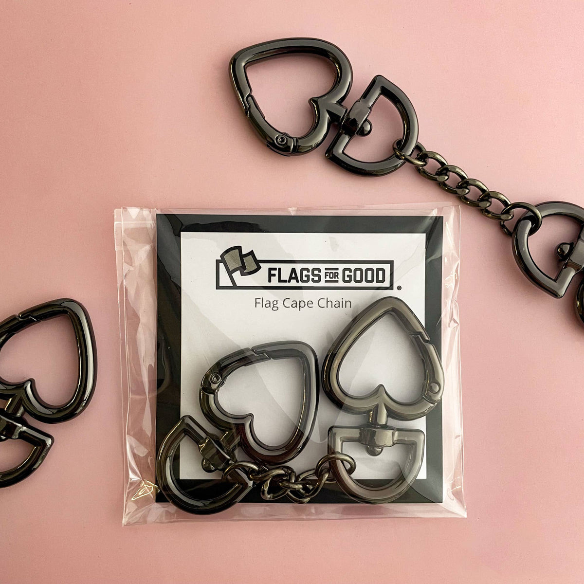 Heart-shaped keychains with packaging labeled 'Flags & Good' on a pink background