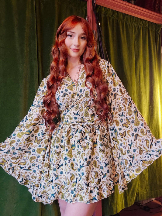 Woman wearing a floral dress with a green curtain background