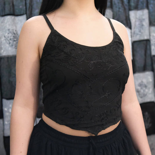 Person wearing a black lace top with a blurred background