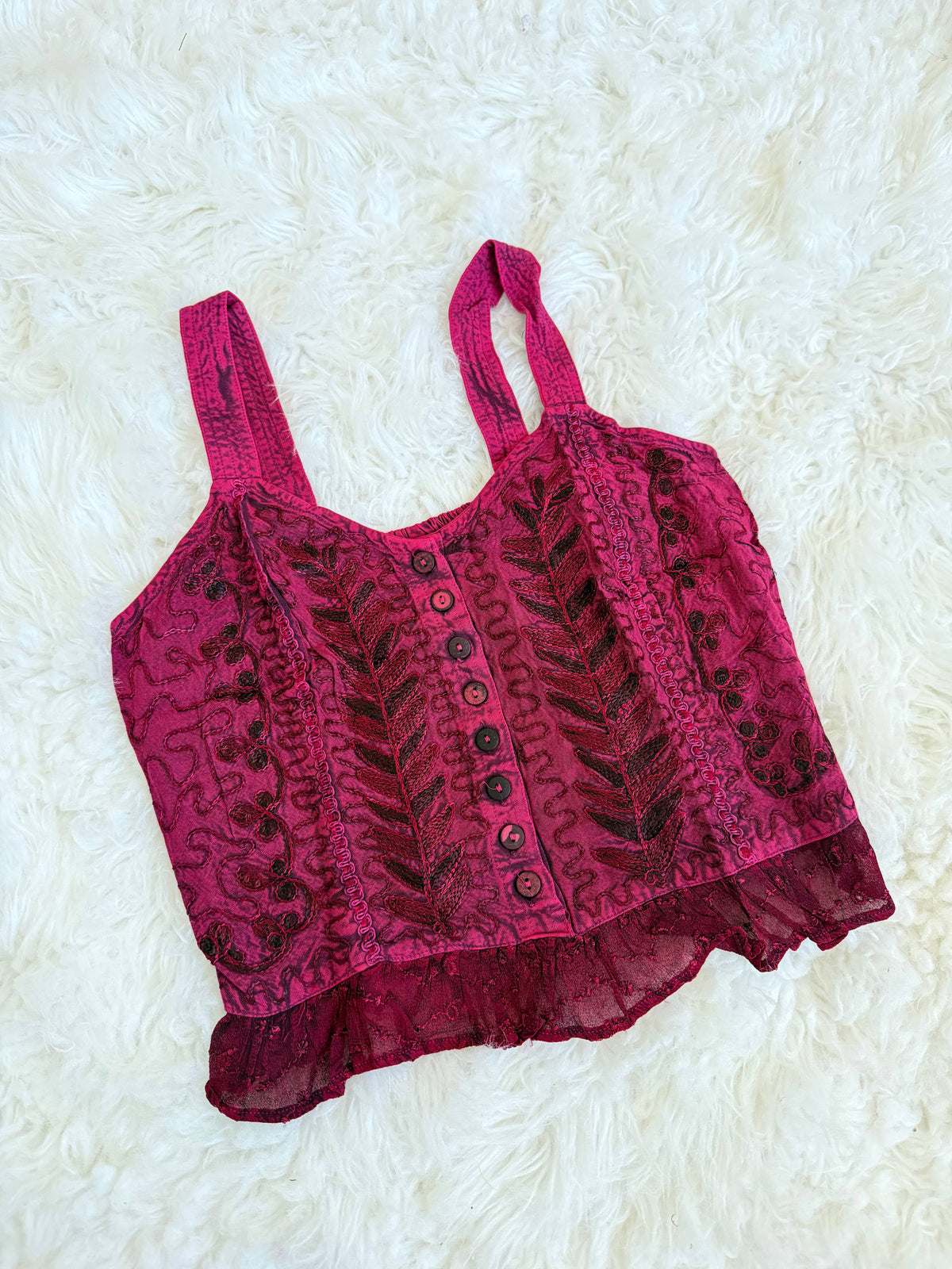 Pink lace crop top on a white textured background