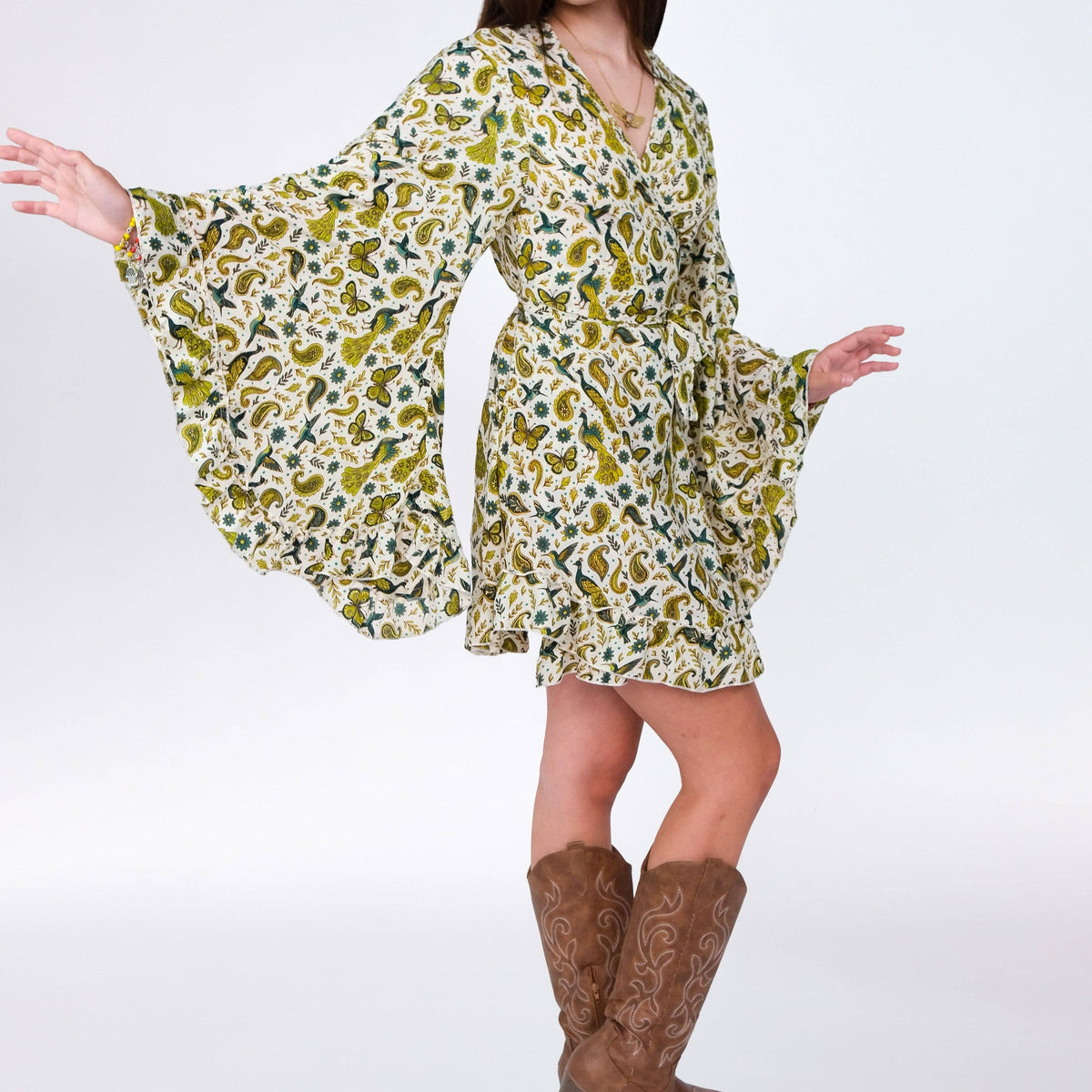 Woman wearing a floral dress and brown boots on a white background