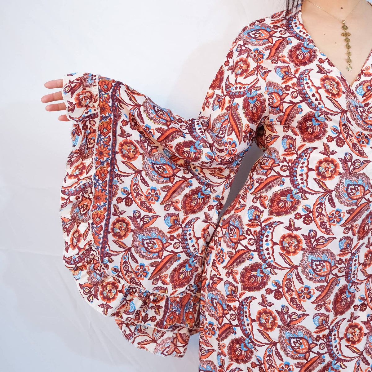 Red and white patterned scarf being held by a person on a white background