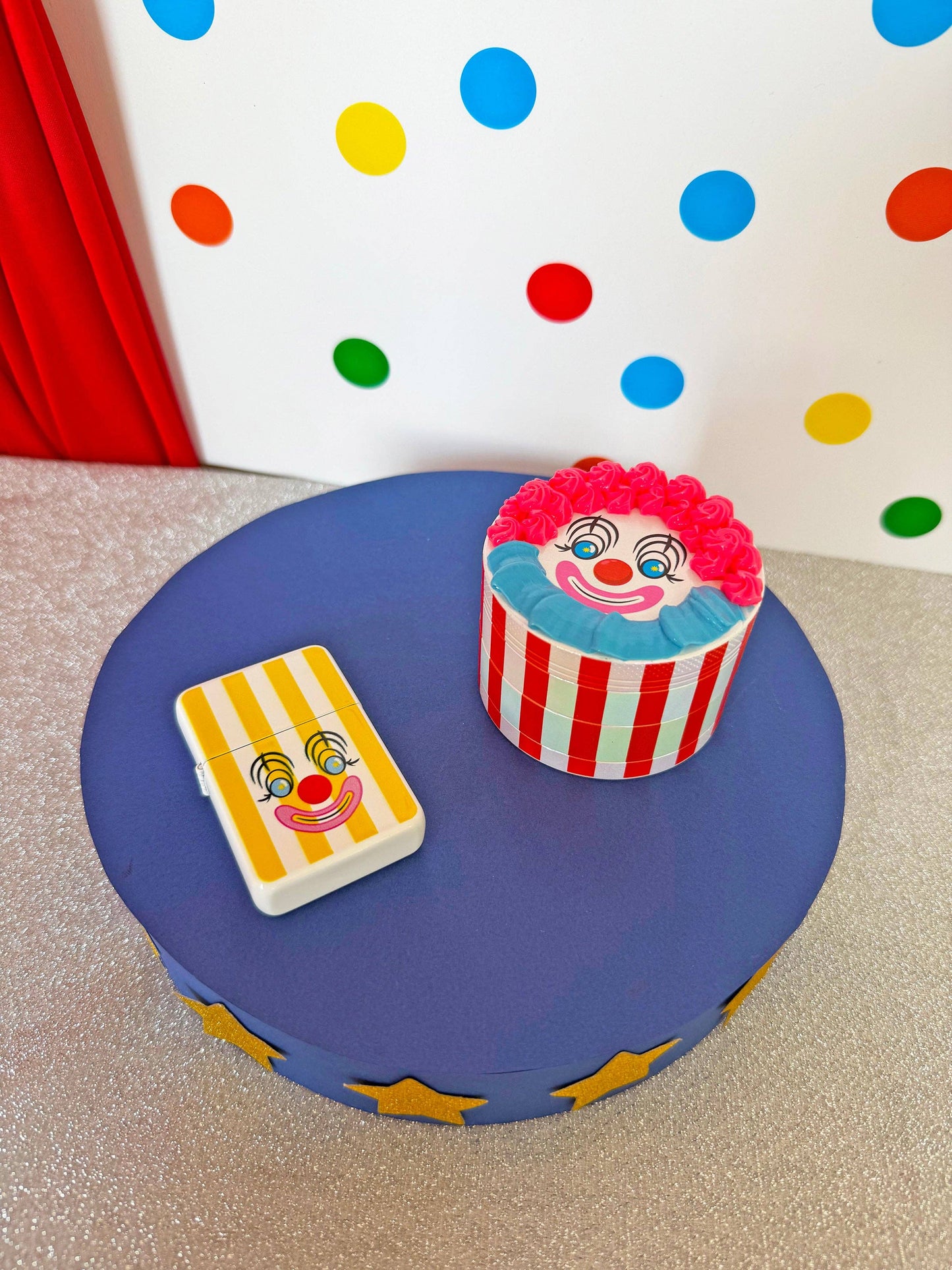 Clown-themed cupcake and card on a blue stand with polka dot background