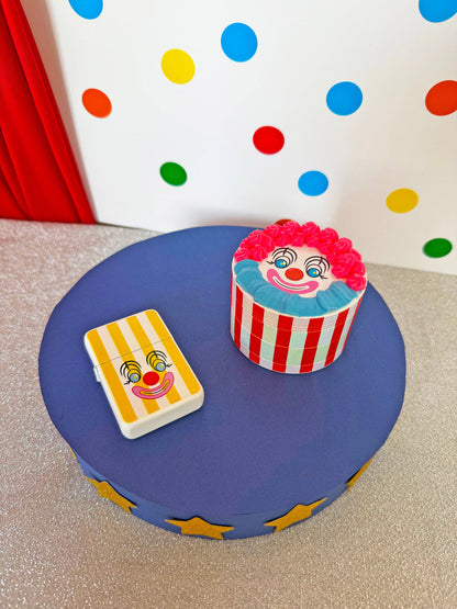 Clown-themed cupcake and card on a blue stand with polka dot background