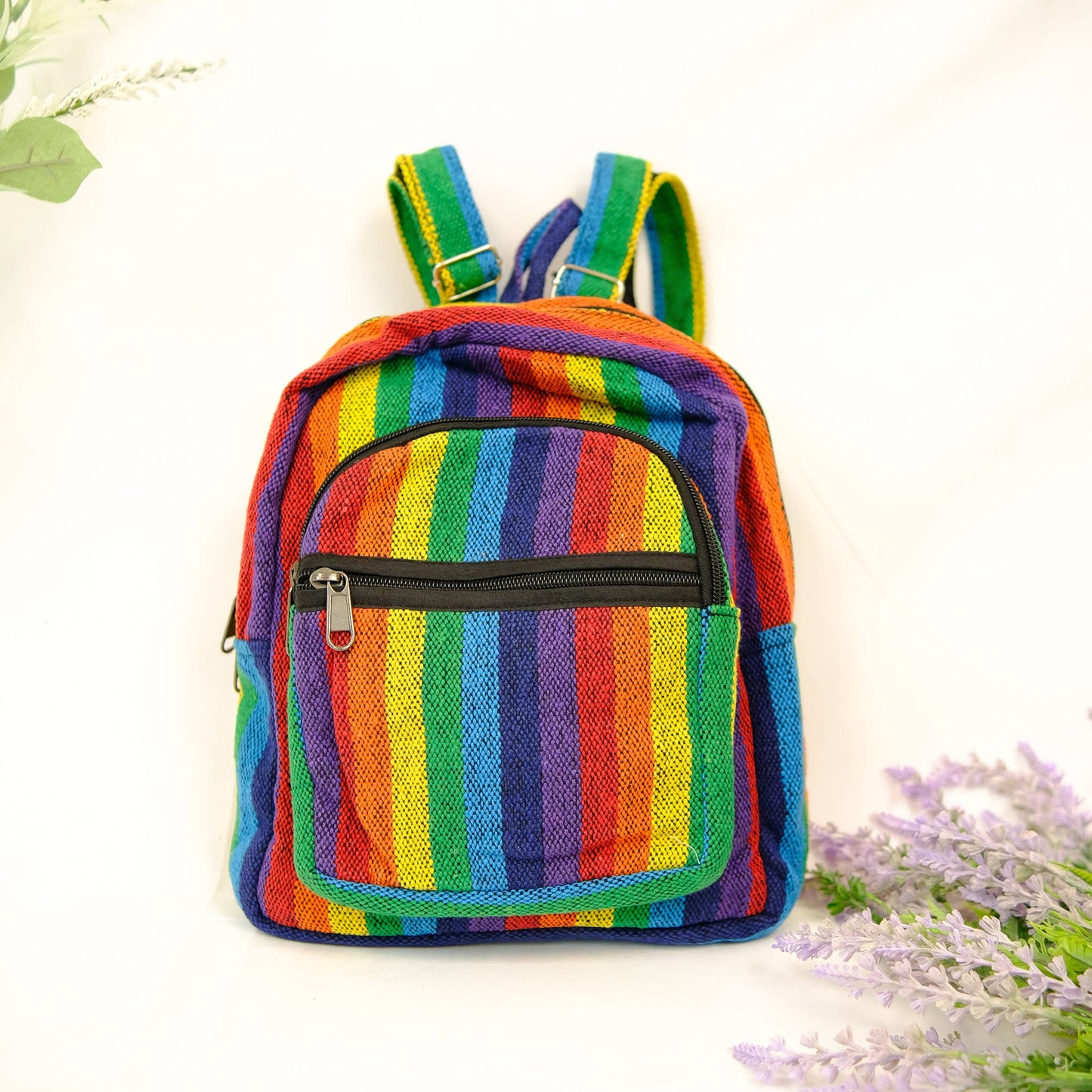 Colorful striped backpack on a white background with flowers.