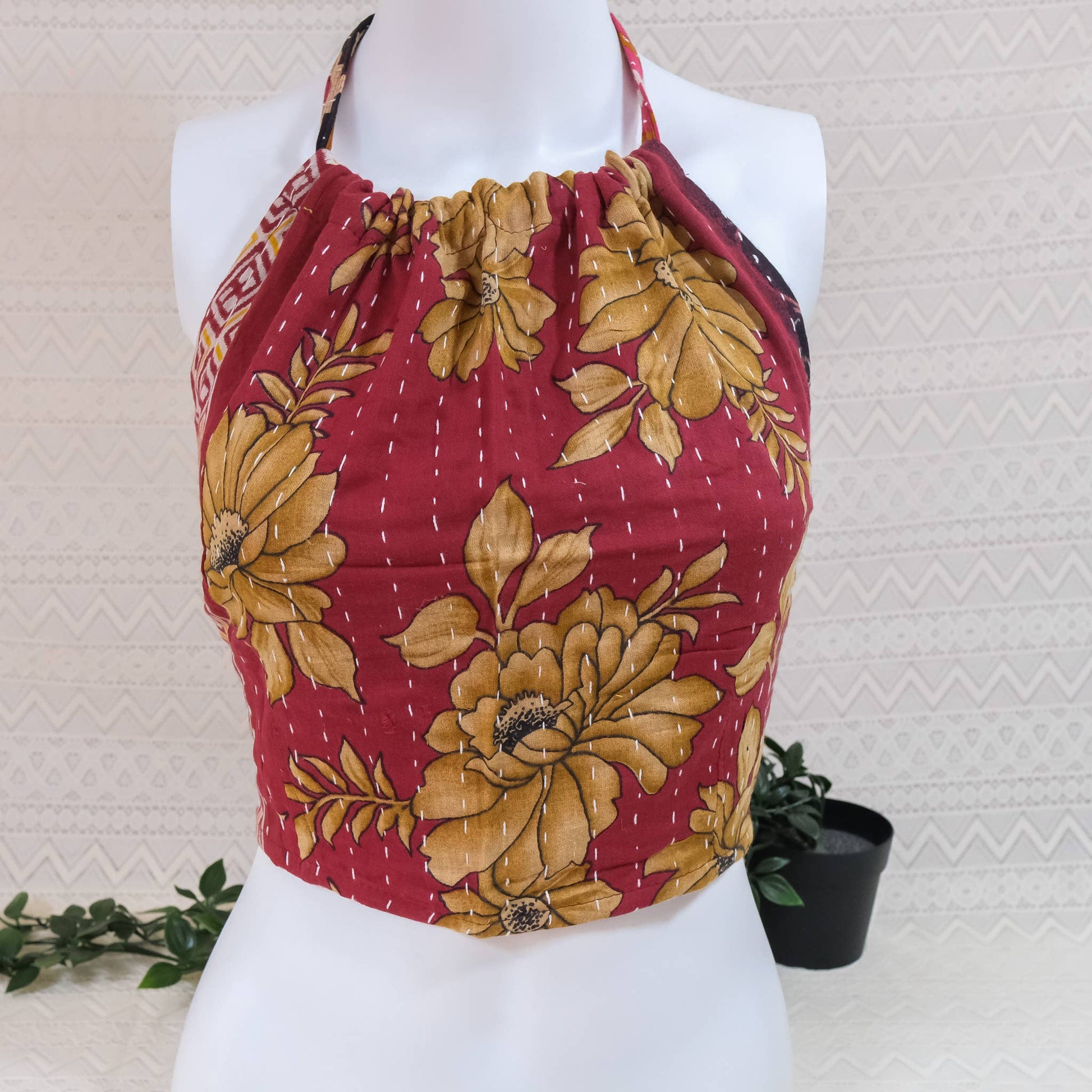 Red and yellow floral patterned top on a mannequin against a light background