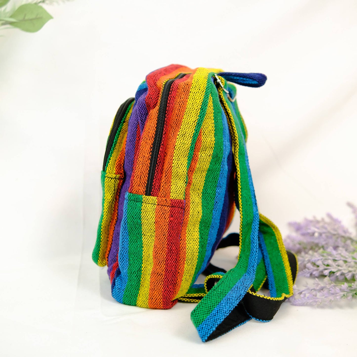 Colorful striped backpack on a white background with lavender flowers.
