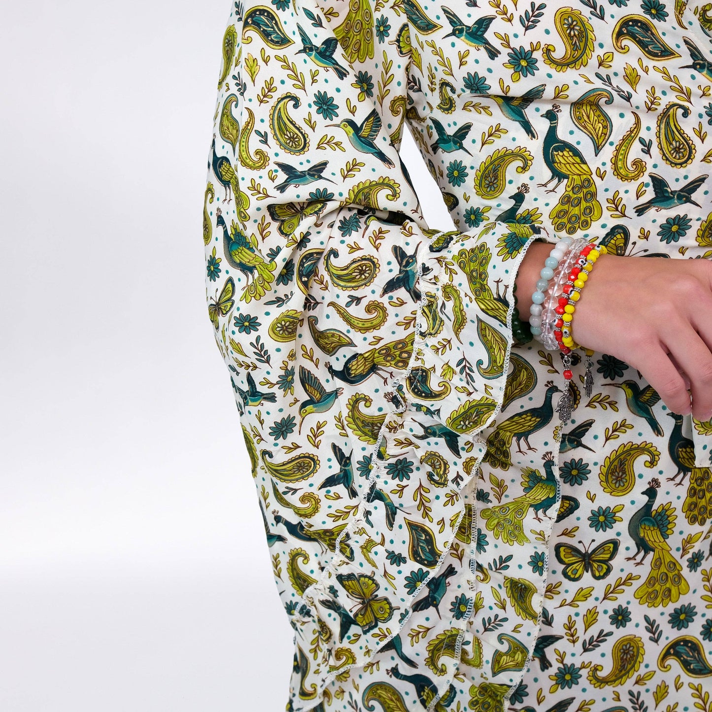Person wearing a patterned outfit with green and yellow designs on a white background