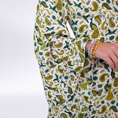Person wearing a patterned outfit with green and yellow designs on a white background