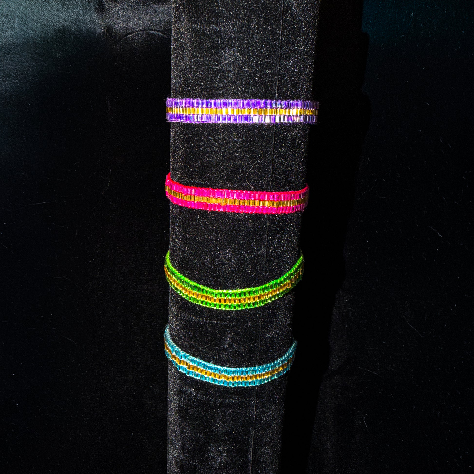 Colorful beaded bracelets on a black background