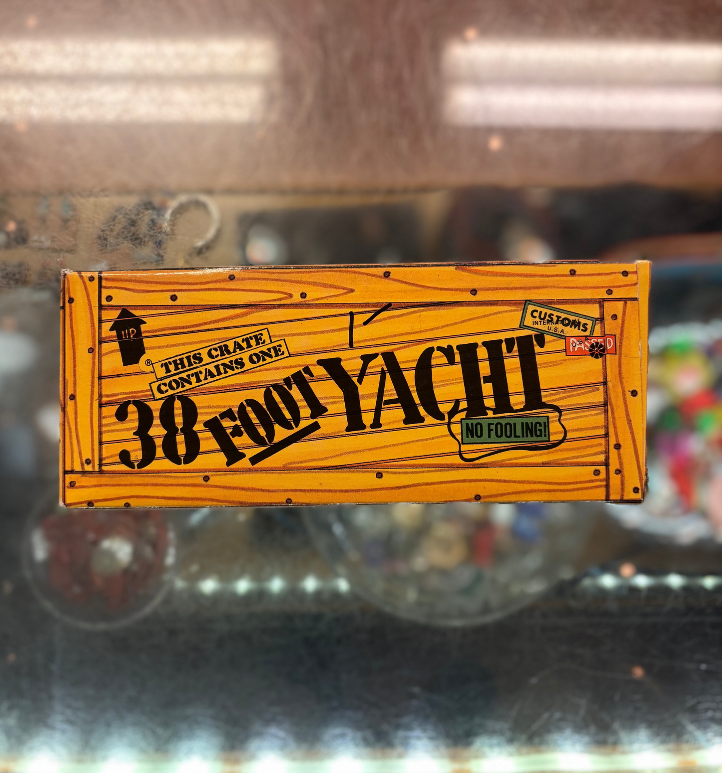 Wooden crate with '38 Foot Yacht' branding on a reflective surface