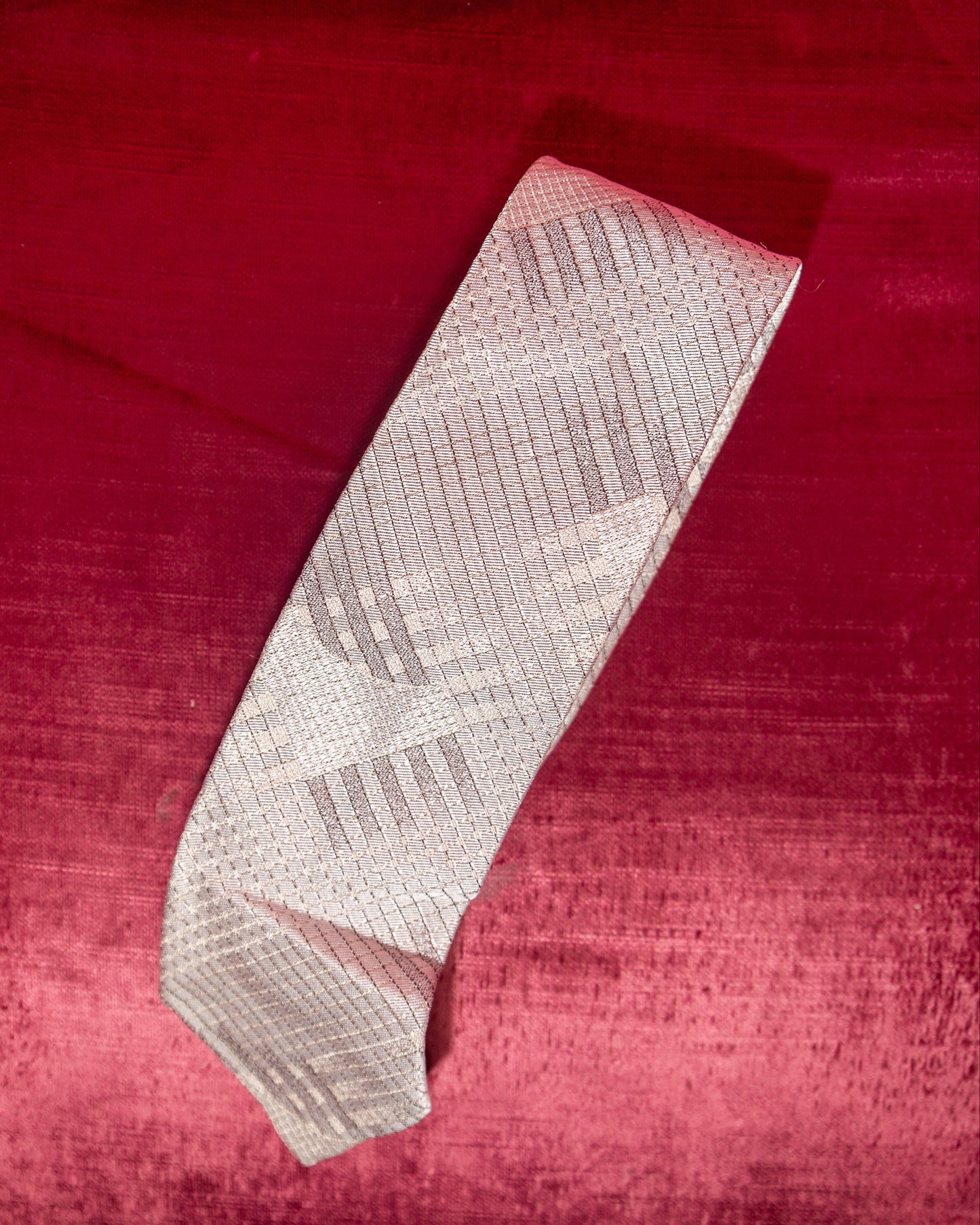 Patterned tie on a red textured fabric background