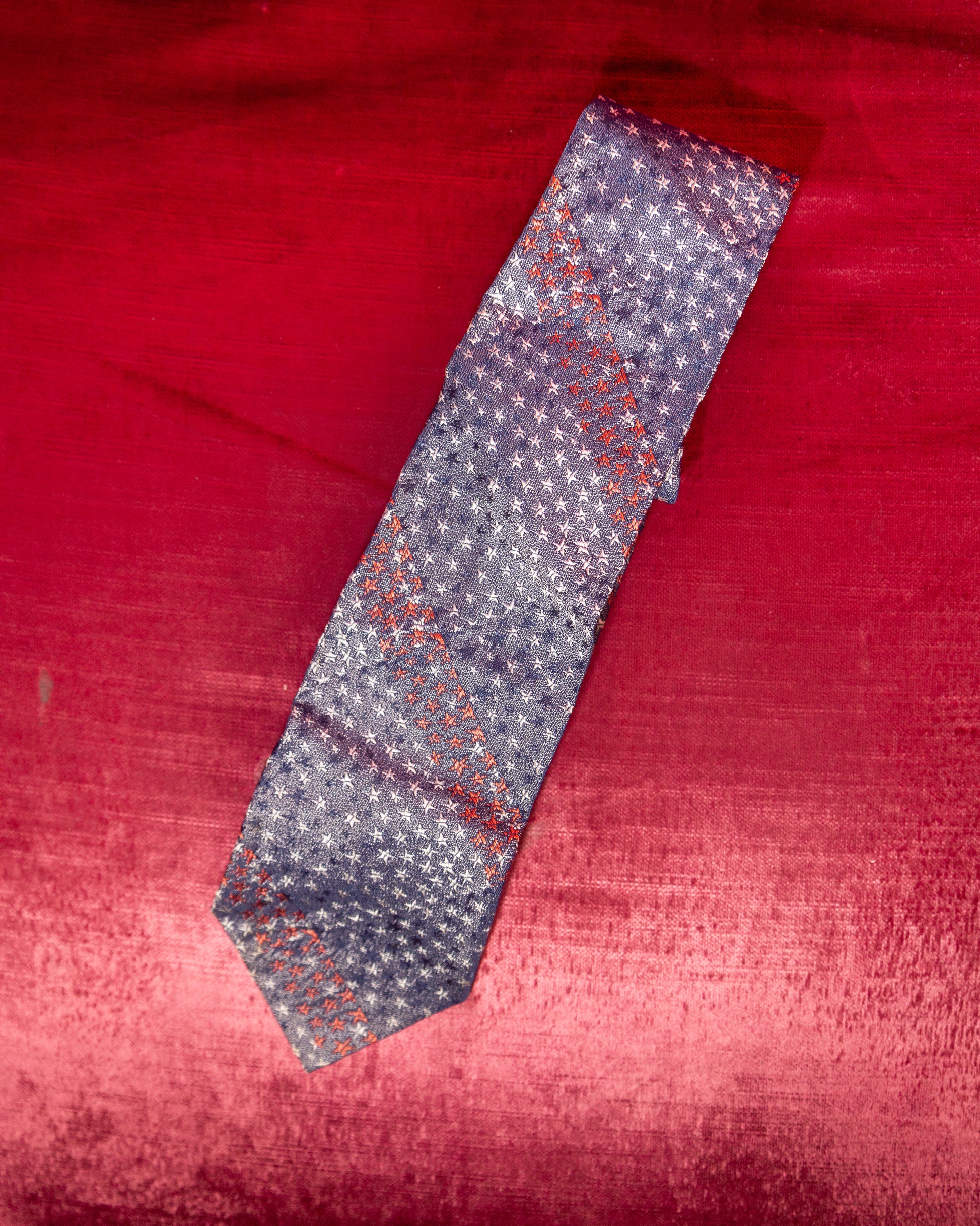 Patterned tie on a red fabric background