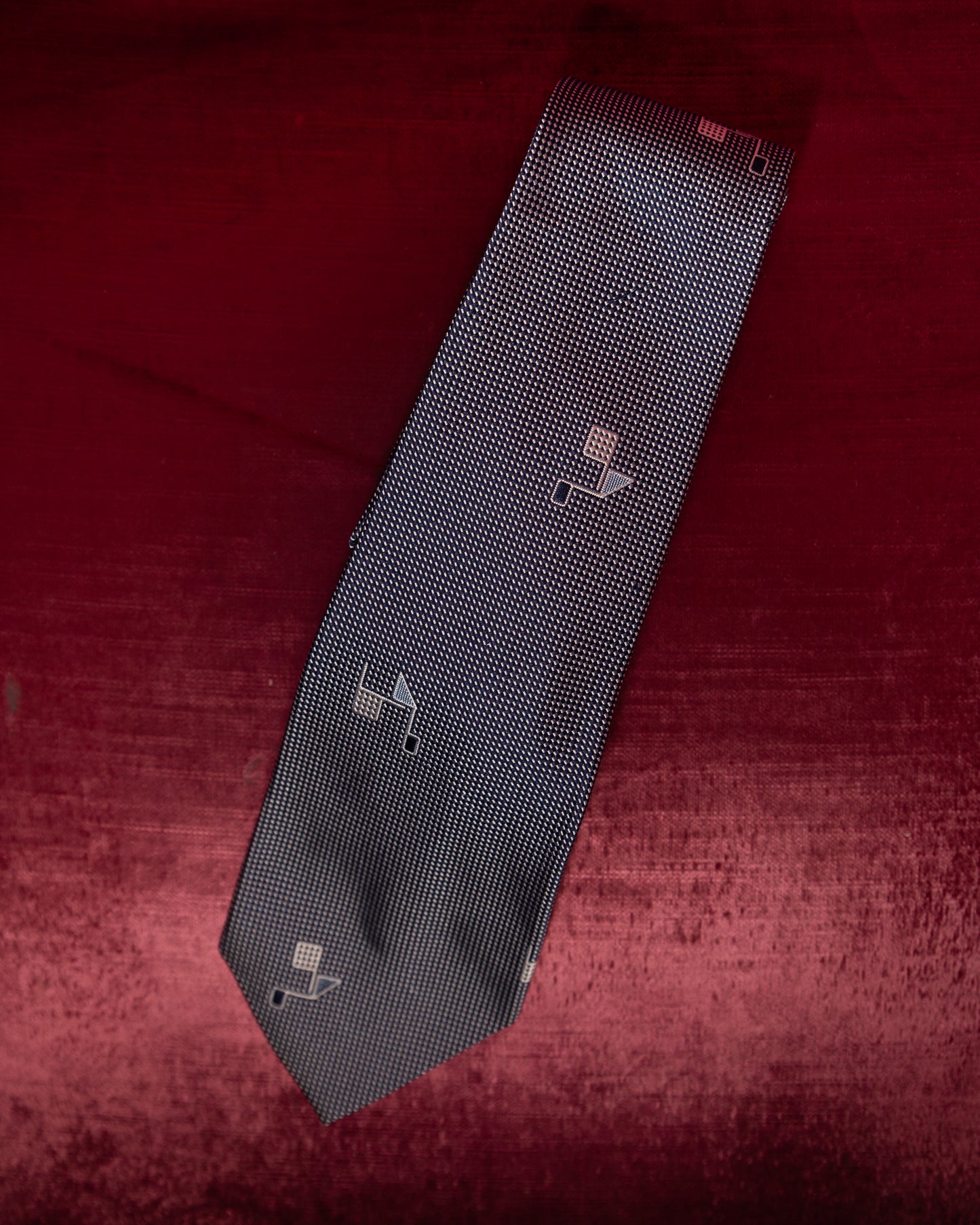 Black patterned tie on a red textured background