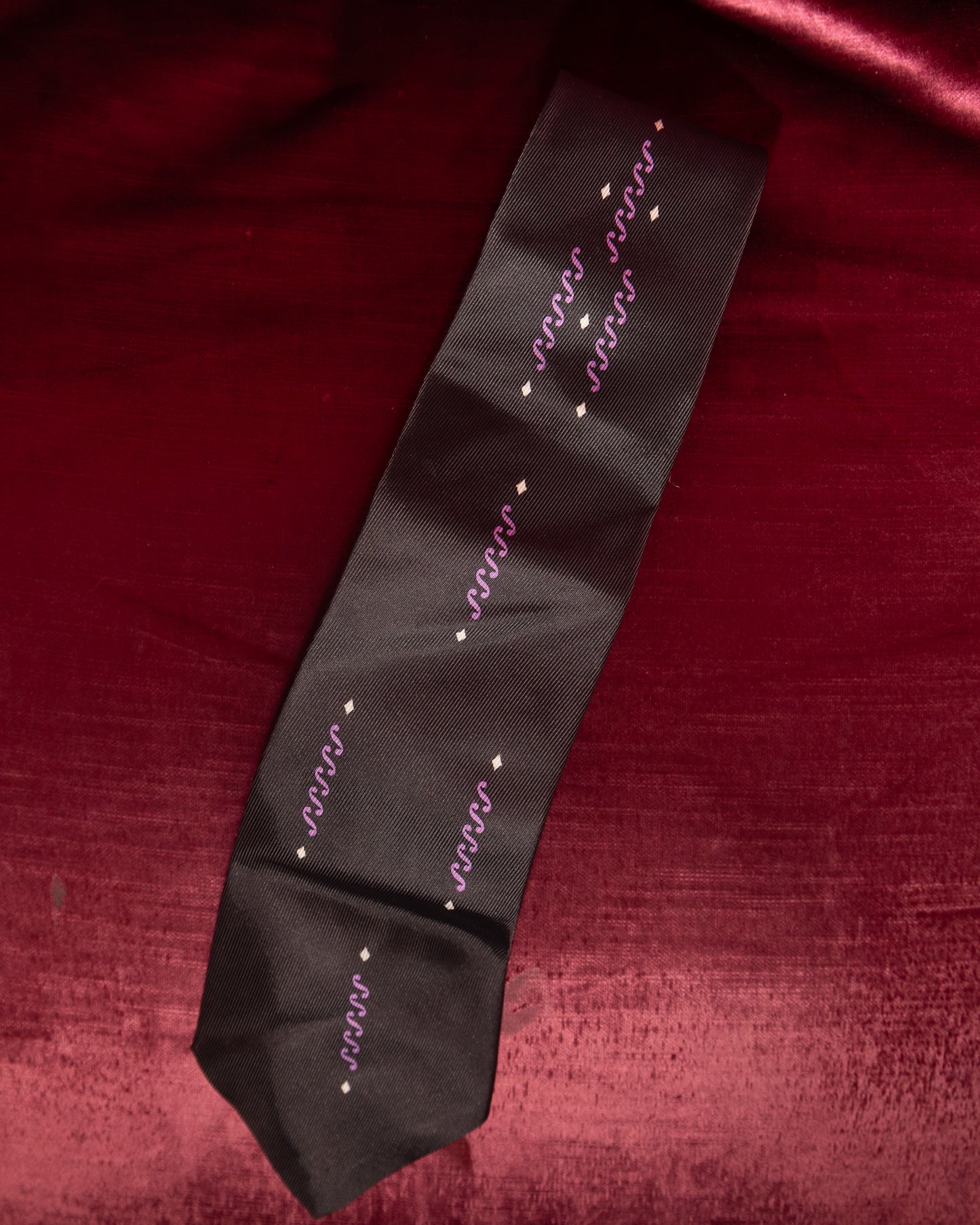 Black tie with white text on a red fabric background