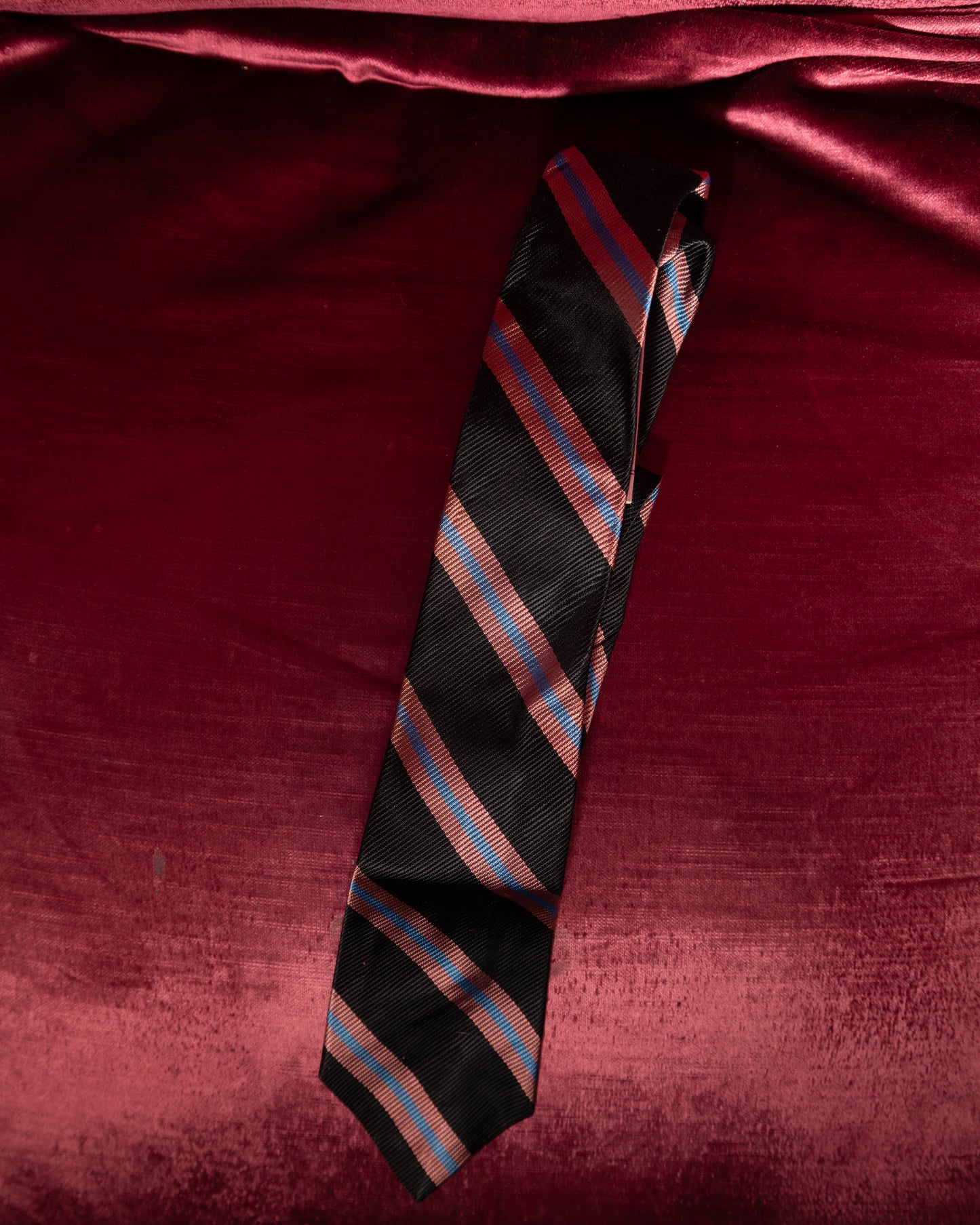 Striped tie on a red fabric background