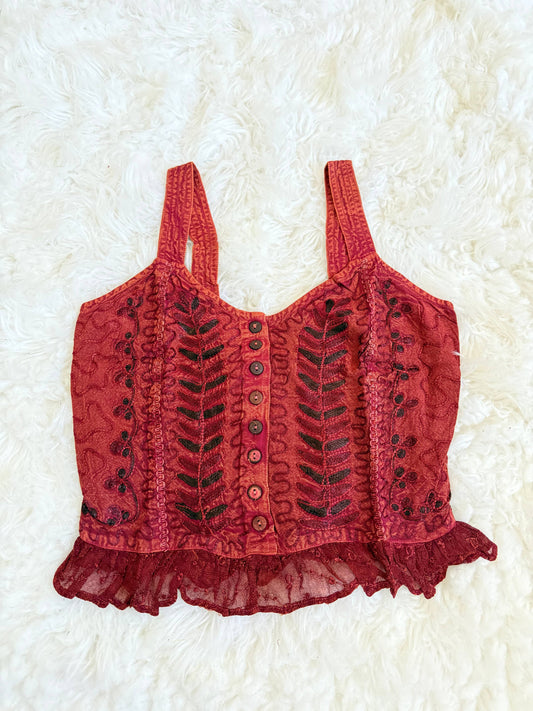 Red lace top with buttons on a white textured background
